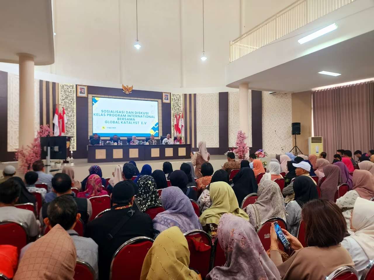 Panggung pernikahan dengan dekorasi bunga di Aula SC Pertamina